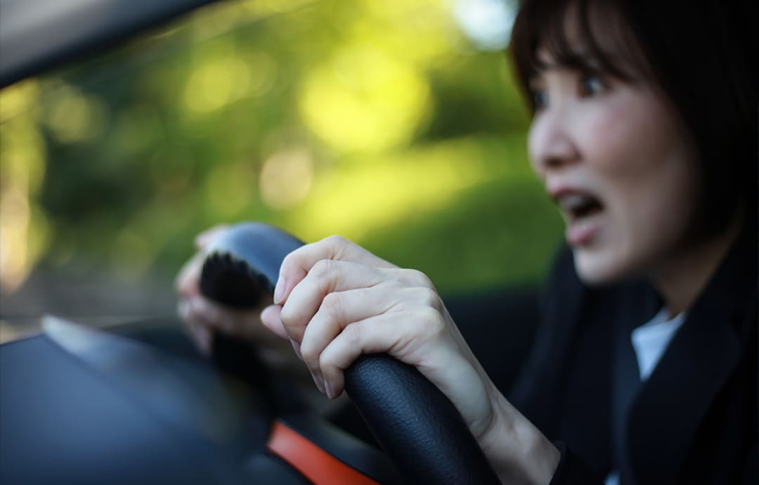 おどろいた表情の運転する女性